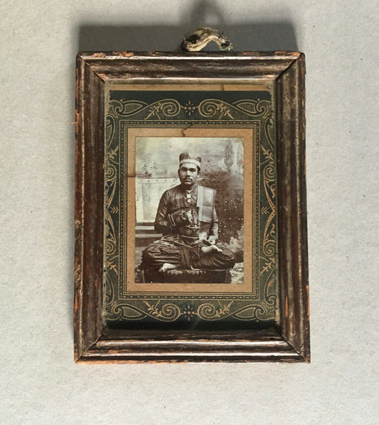 East — studio portrait of a dignitary in a suit seated cross-legged — c. 1900.