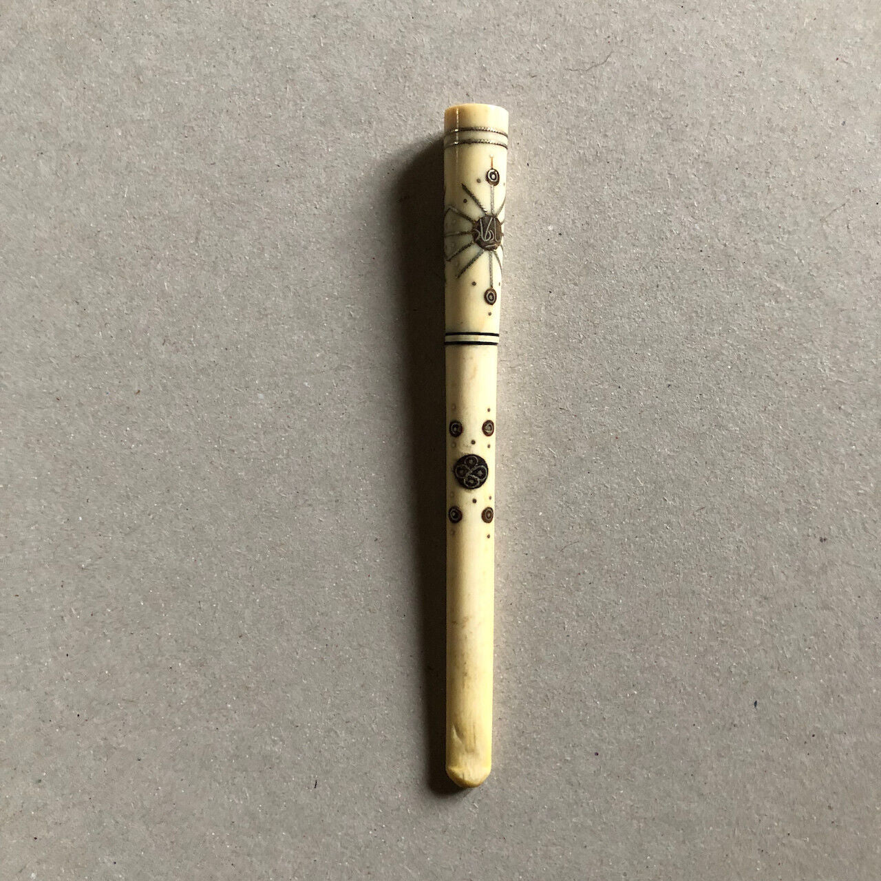 Fume-cigarette en os — décor incrustation ébène & argent — circa 1930.