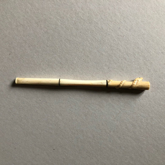 Fume-cigarette en os sculpté d'un serpent enroulé — circa 1930.