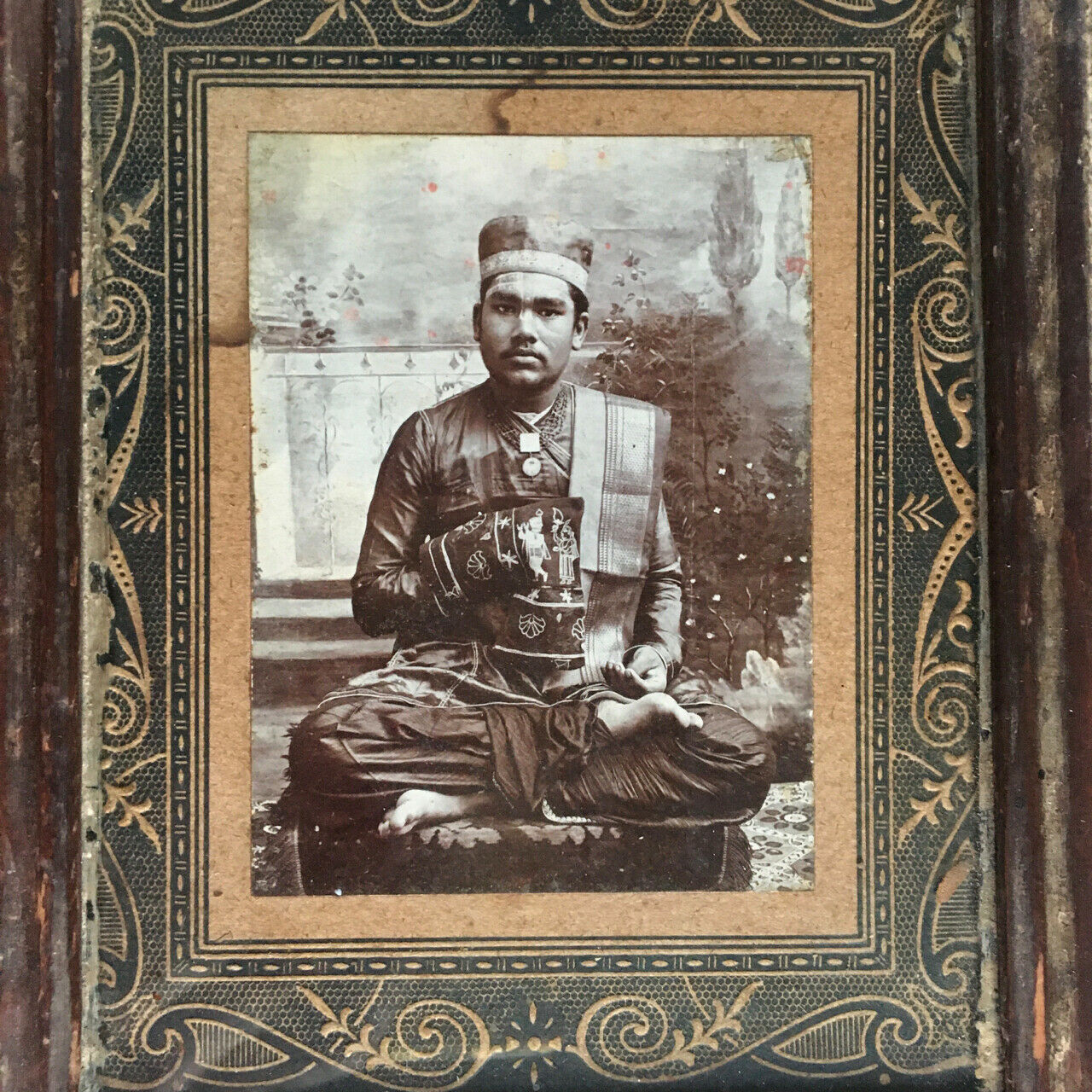 Orient — portrait studio d'un dignitaire en costume assis en tailleur — c. 1900.